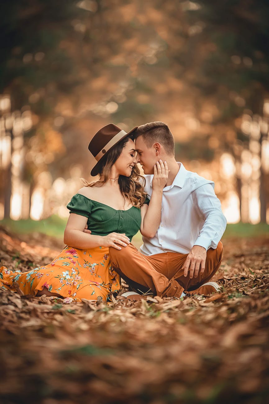 Young white couple sitting outside in nature holding each other