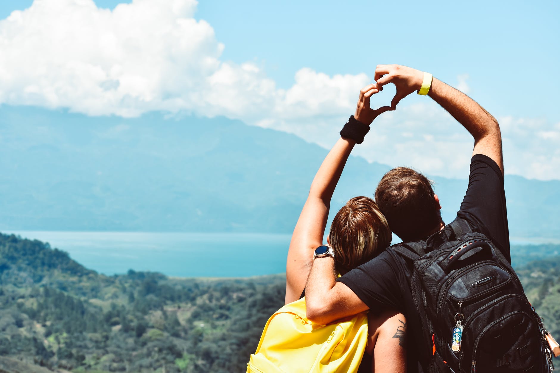 Couple paired by free matchmaking standing and hugging holding heart hands in the air