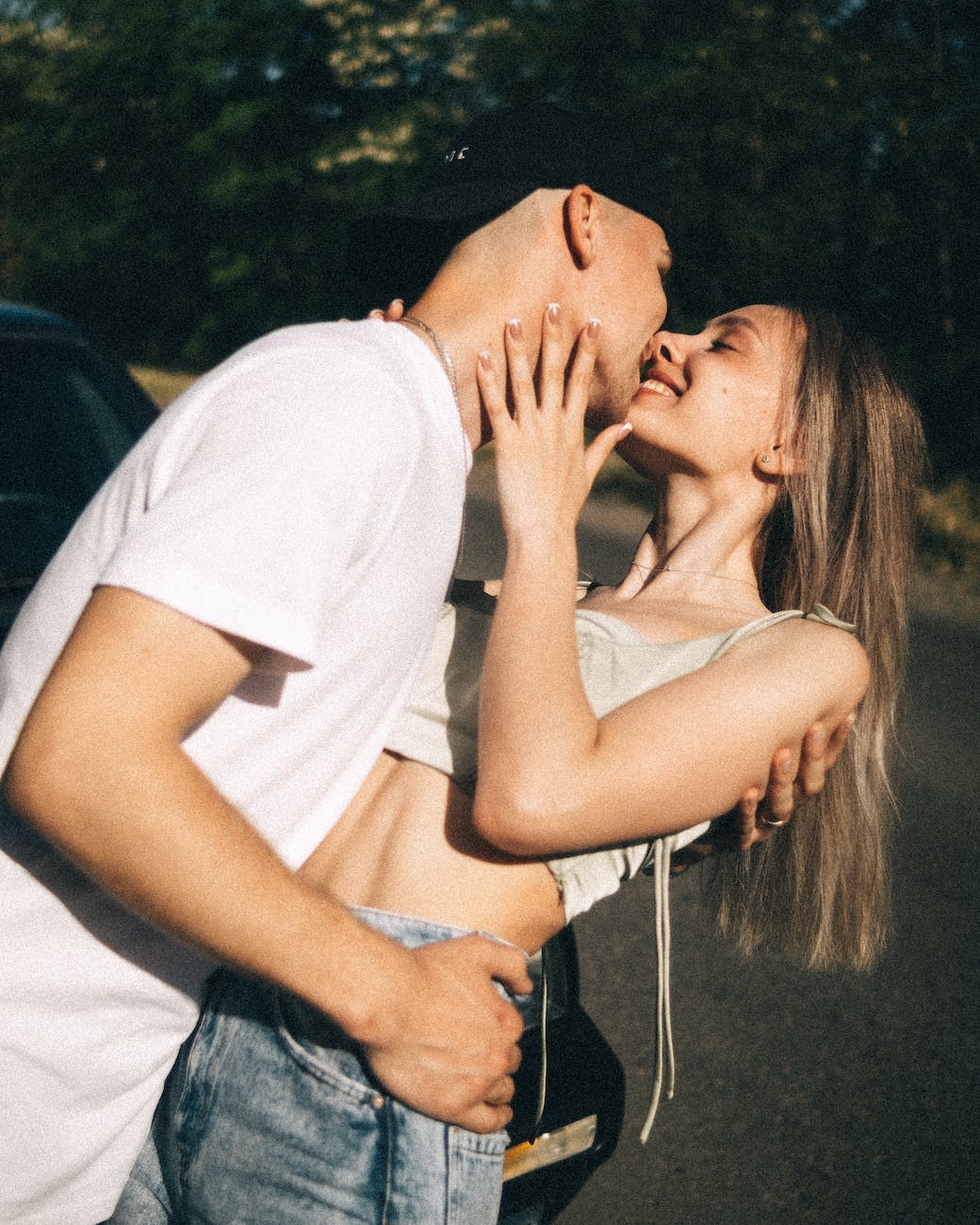 Young Caucasian couple kissing in the sunshine in the street
