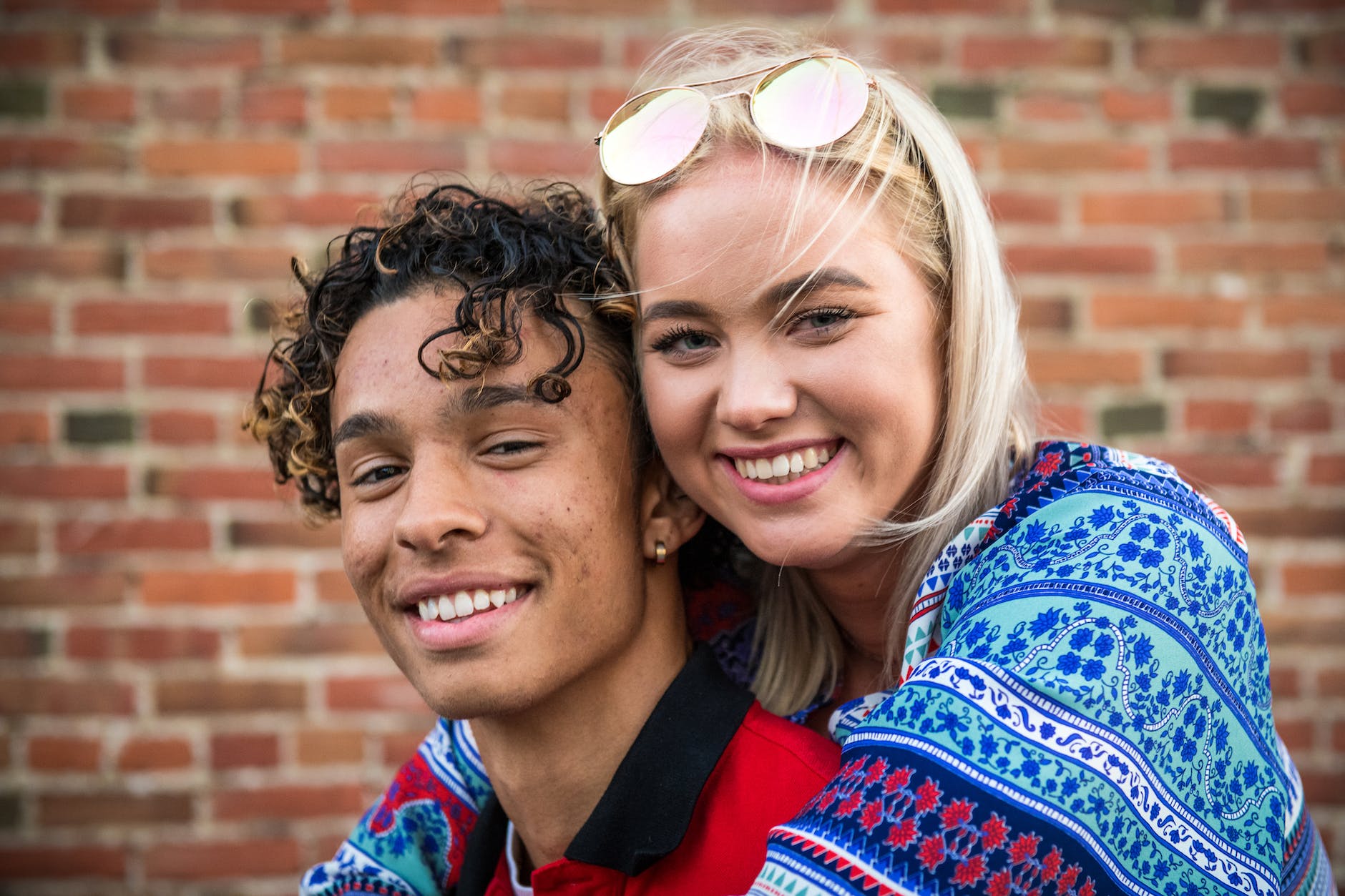 Interracial couple hugging and smiling at the camera