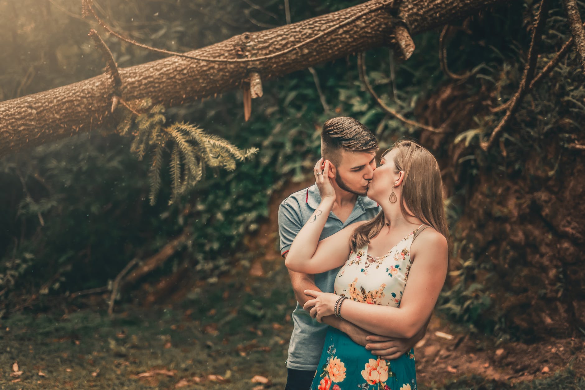 White couple paired by a free dating site without payment kissing under a tree