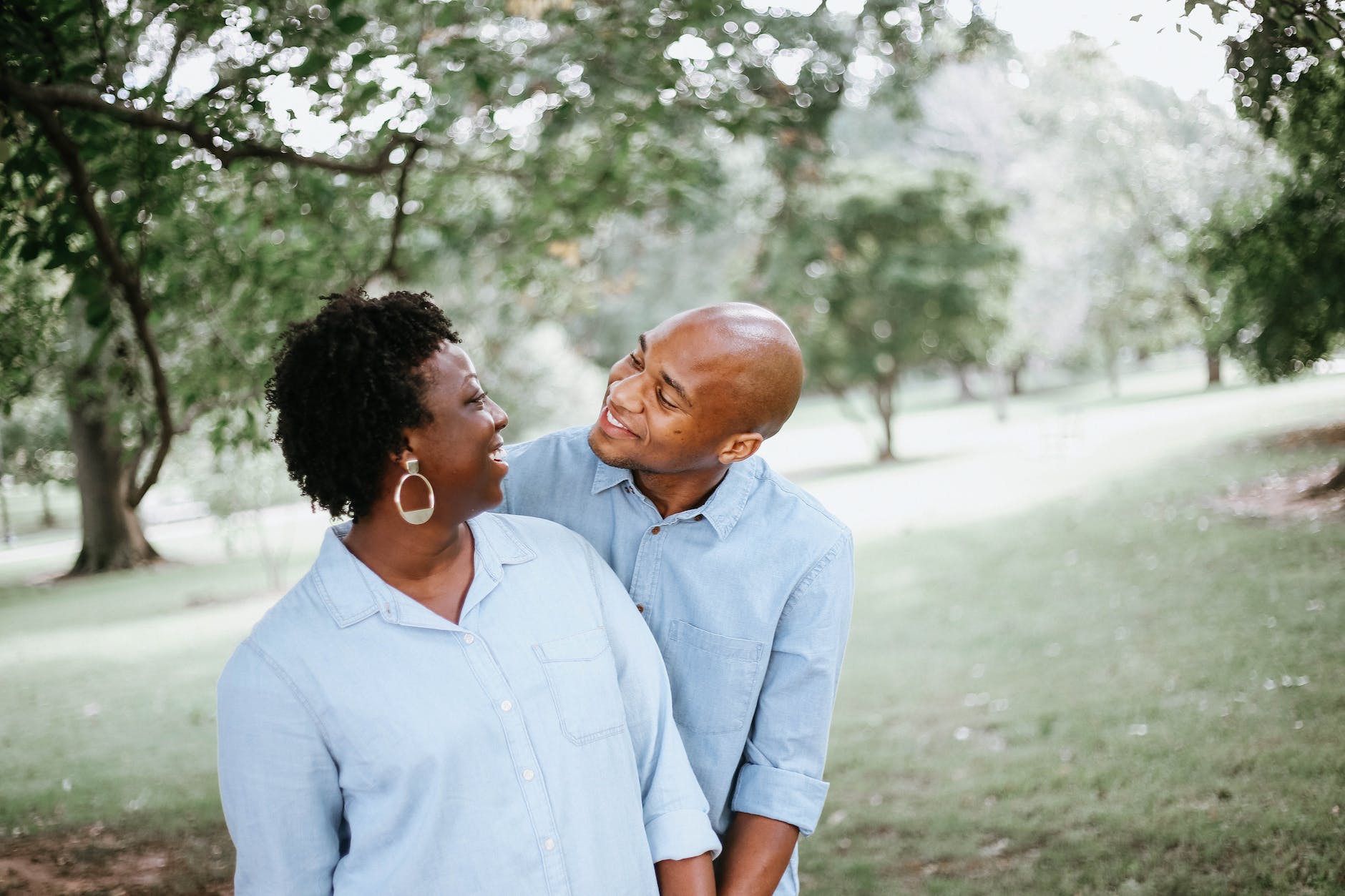 African American couple smiling at each other under a tree