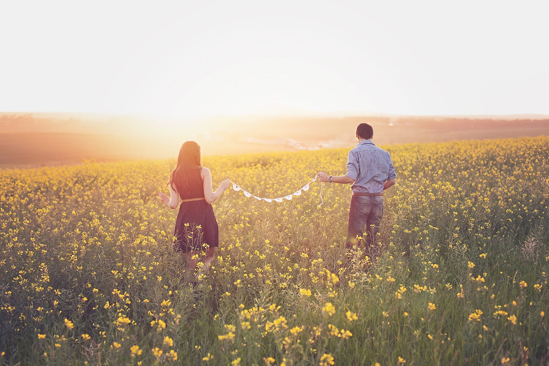 Couple paired by celebrity matchmaking walking in a field of flowers