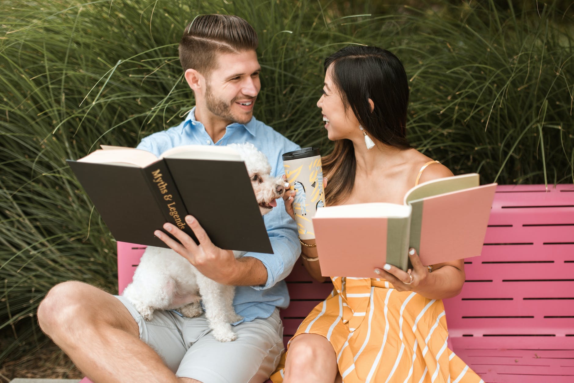 Celebrity matchmaking couple reading books on a pink bench