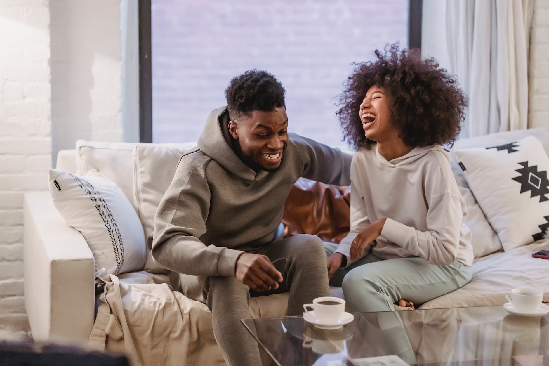 African American couple sitting on a couch laughing