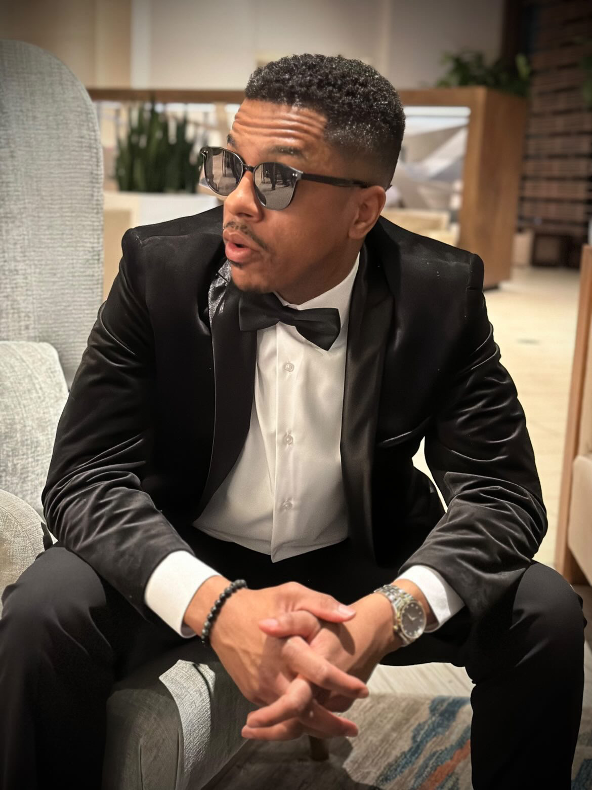 Dating coach for men Michael Smoke wearing a black suit and tie wearing sunglasses