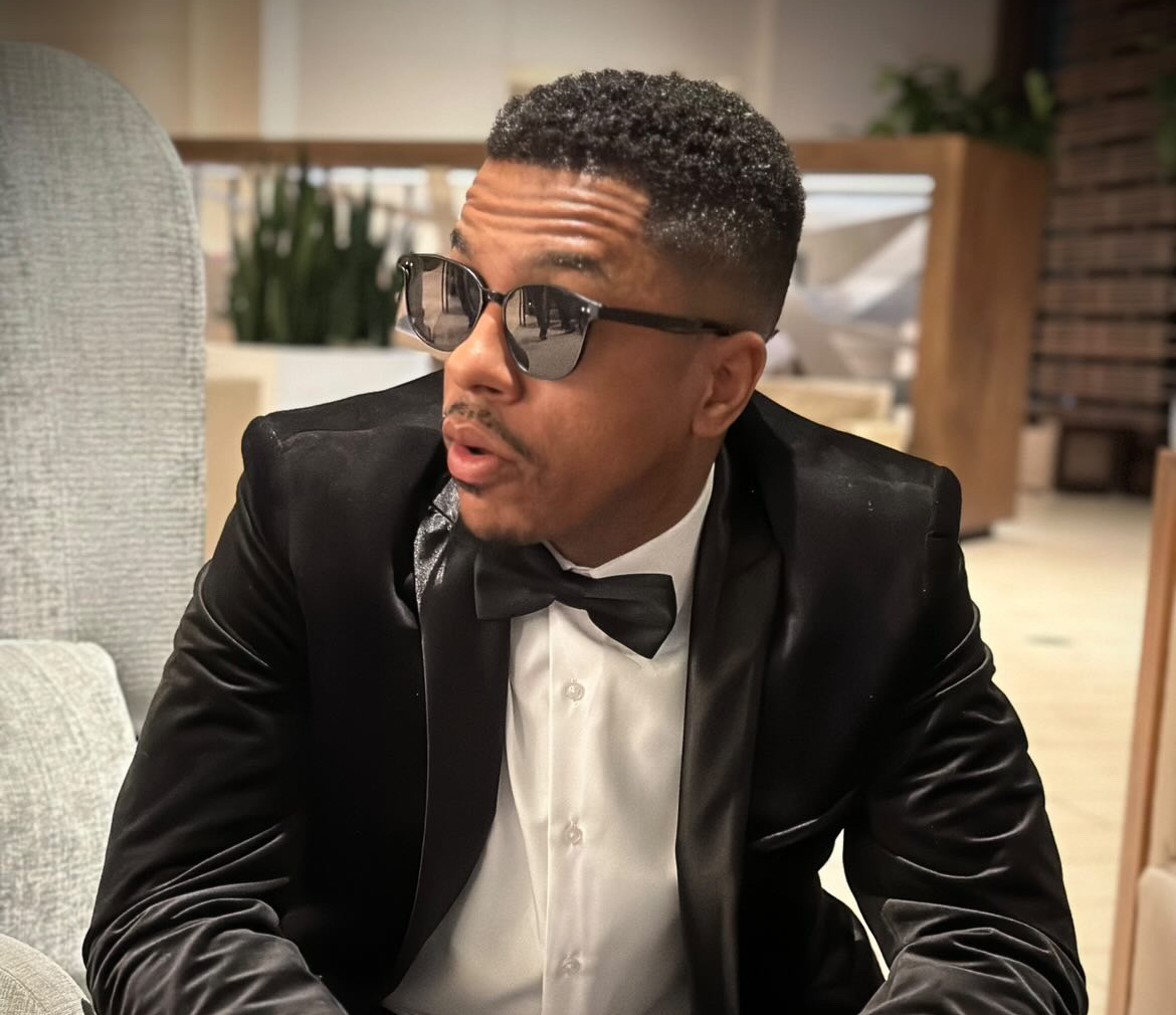 Dating coach for men Michael Smoke wearing glasses while wearing a black suit