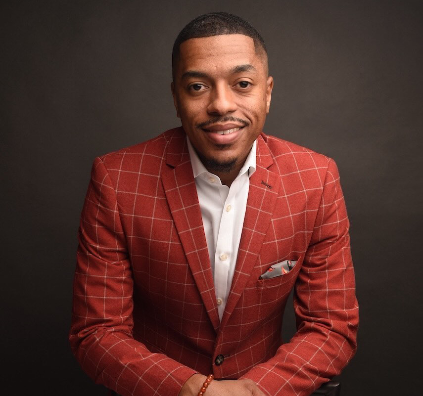 Dating and relationship coach Michael Smoke wearing a red suit and smiling