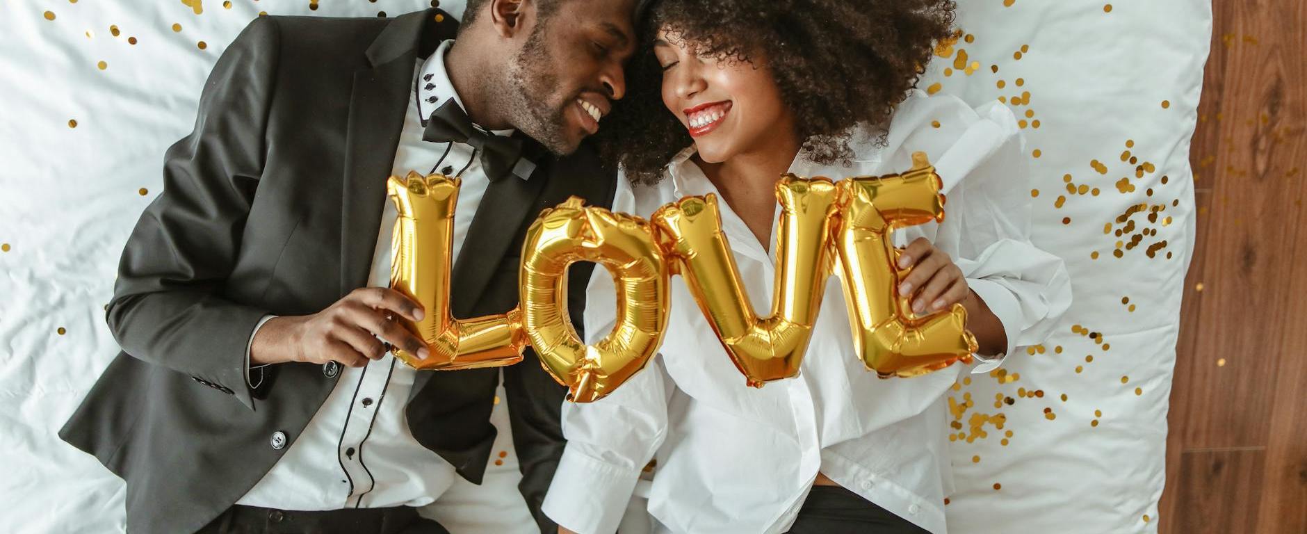 African American couple holding up a love sign after finding out how to heal from a broken heart