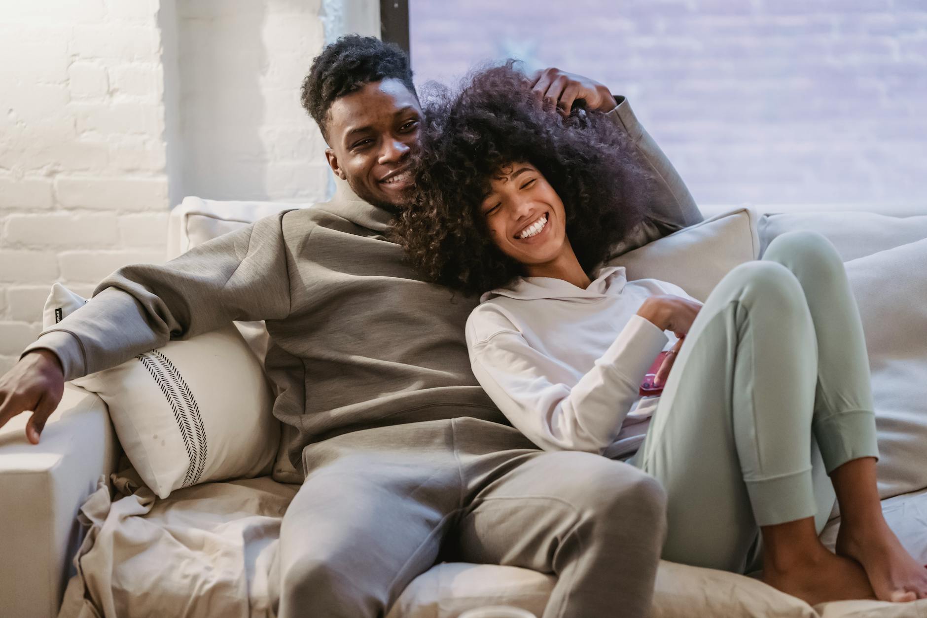 Cute black couple united by Columbus matchmakers sitting on a couch smiling