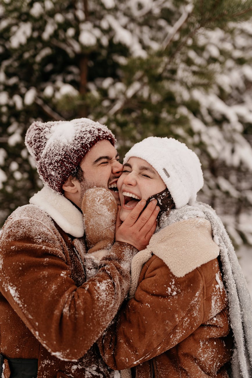Caucasian couple united by matchmakers in Raleigh kissing in the snow outdoors