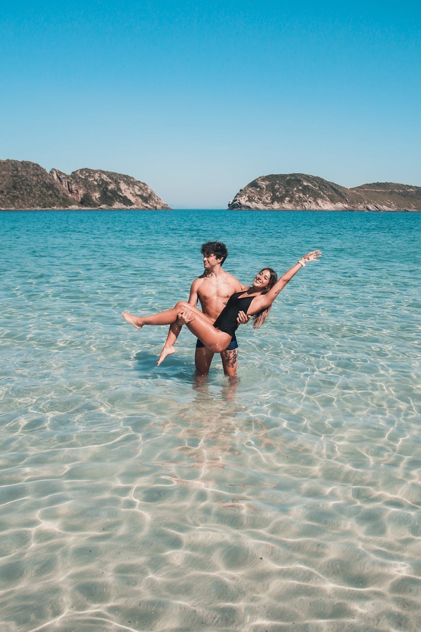 Young white couple united by Fort Lauderdale matchmakers having fun in the water on a beach