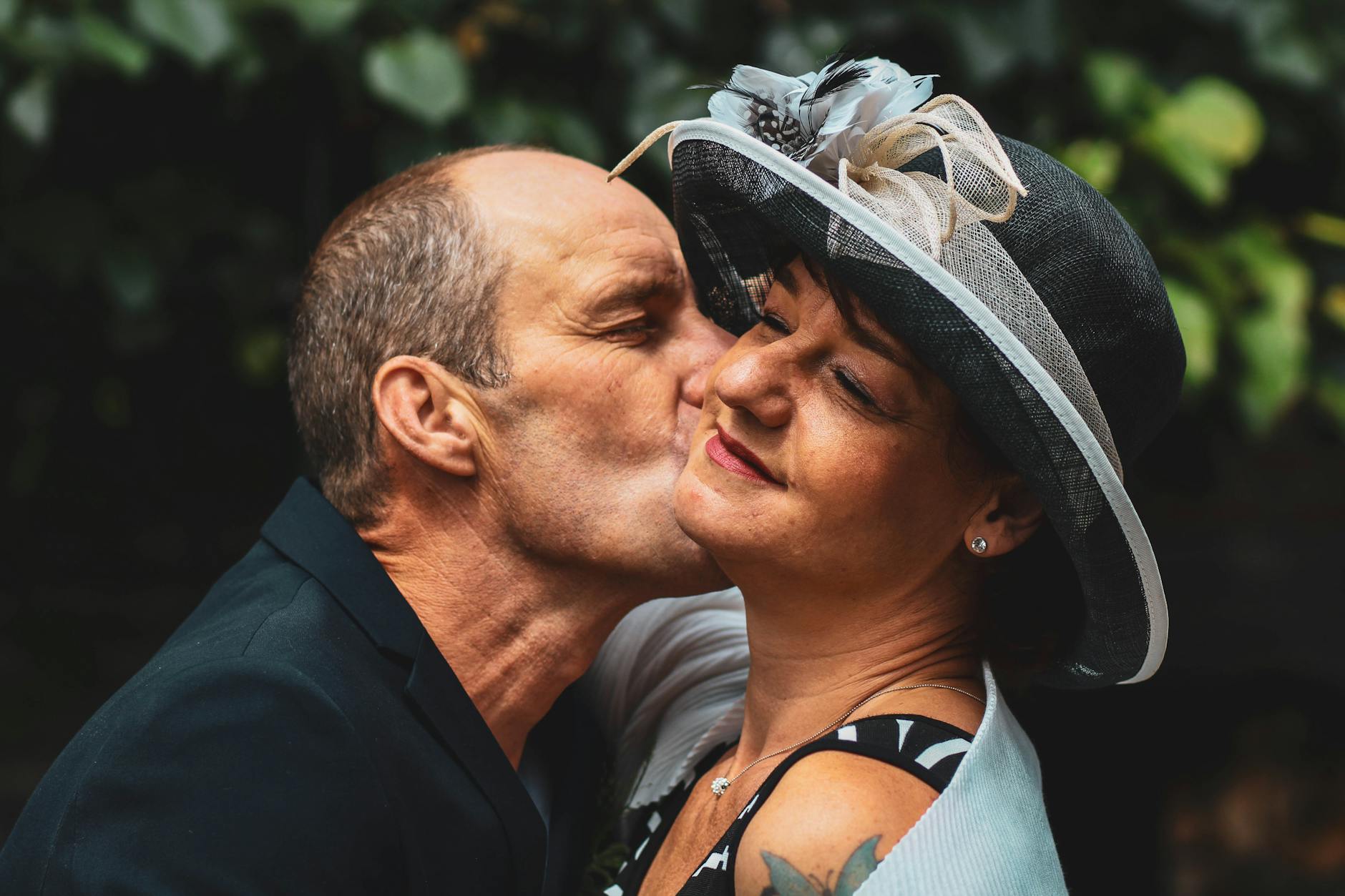 Older Caucasian couple kissing in formal clothes