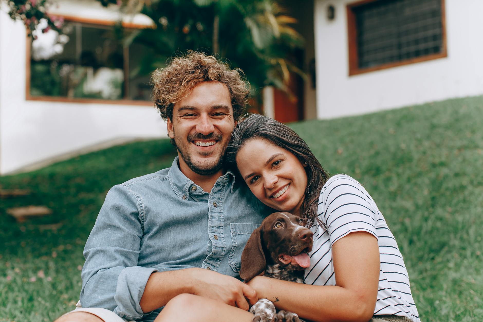 Cute Caucasian couple united by matchmakers in Charleston hugging while holding a brown dog