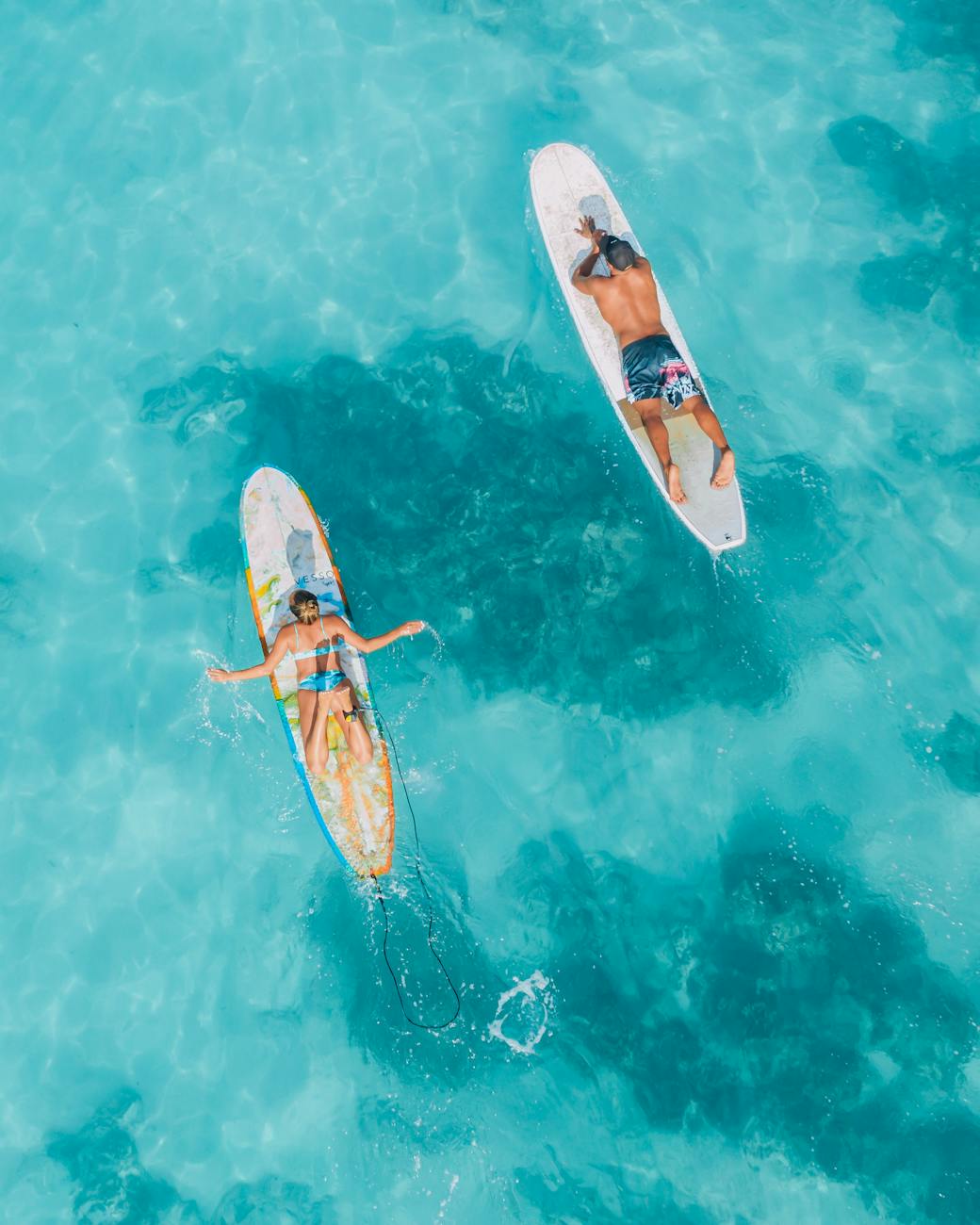 Caucasian couple united by matchmakers in Tampa floating on surfboards in the ocean