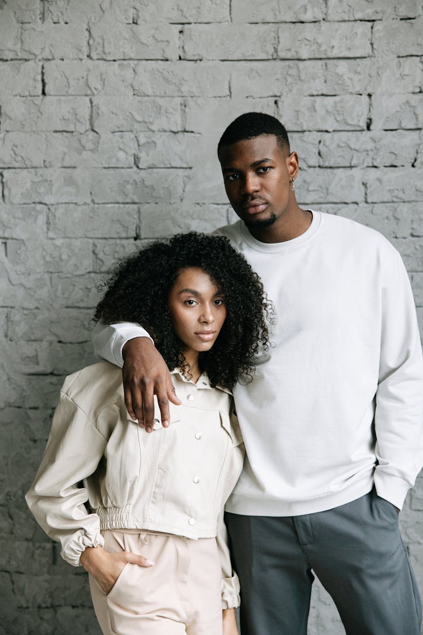 Attractive African American couple united by matchmakers in Alexandria standing in front of a gray wall