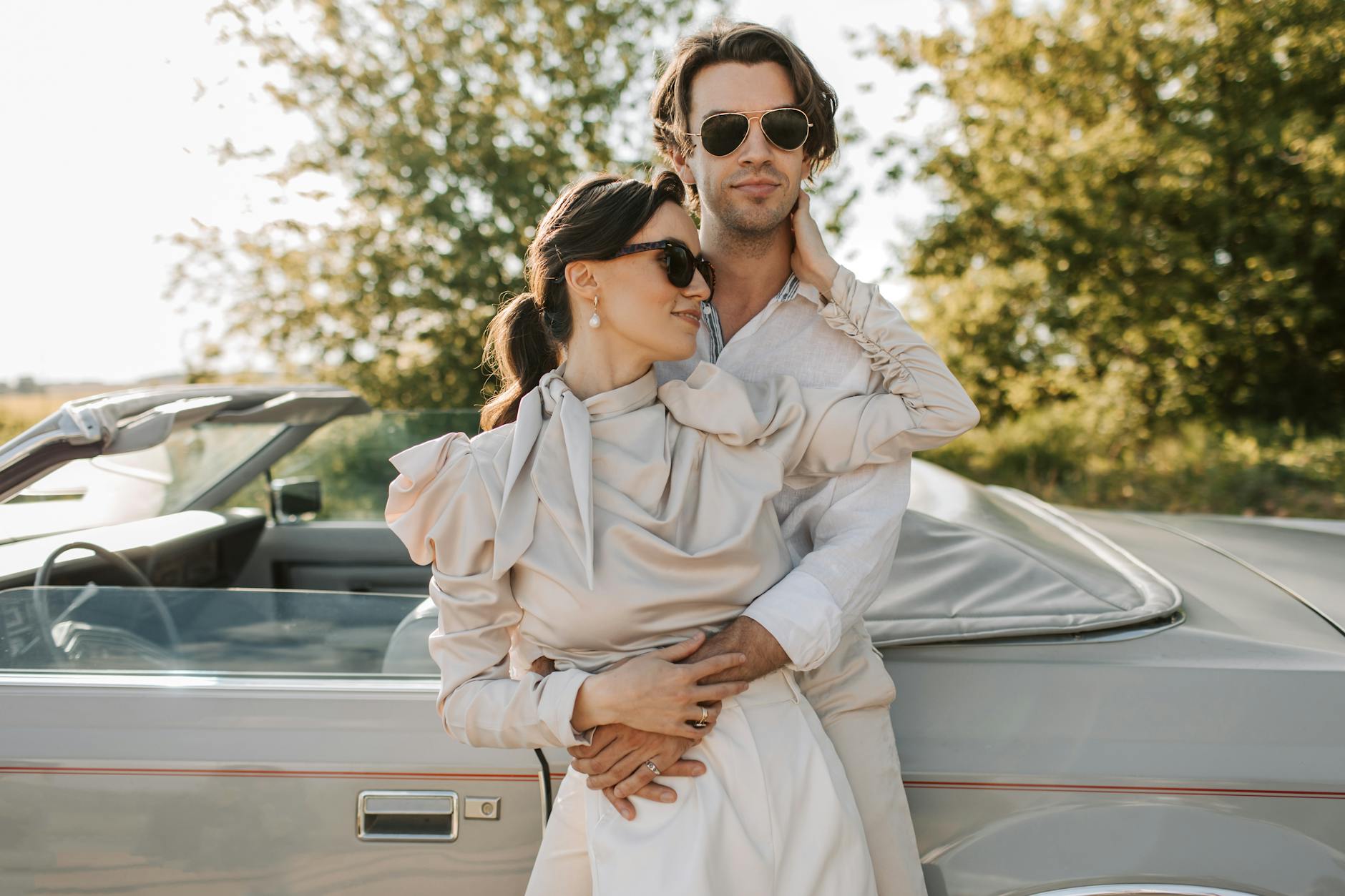 White couple united by matchmakers in New Orleans standing in front of a car embracing