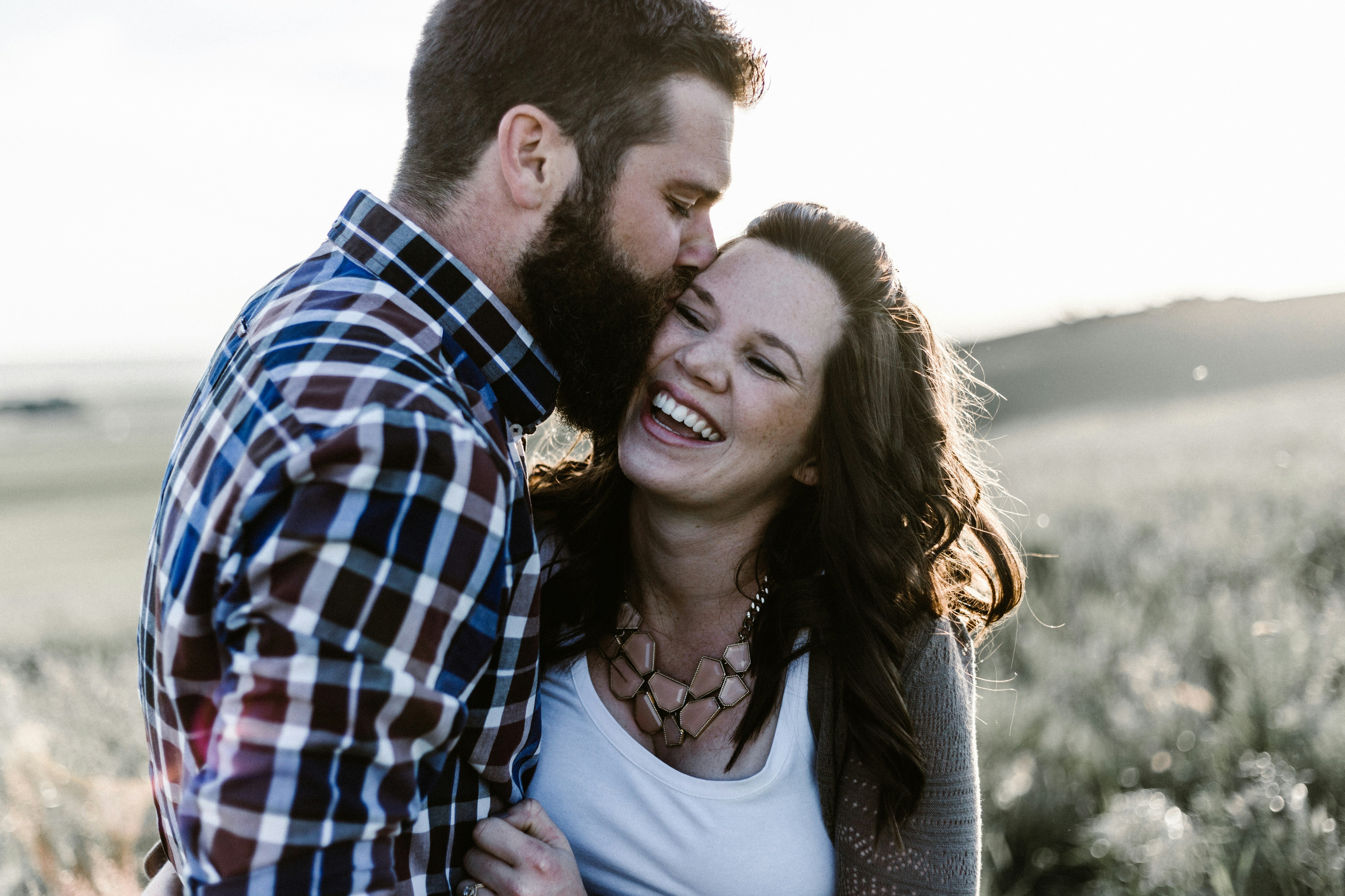 White couple paired by Atlanta matchmaking cuddling in a field