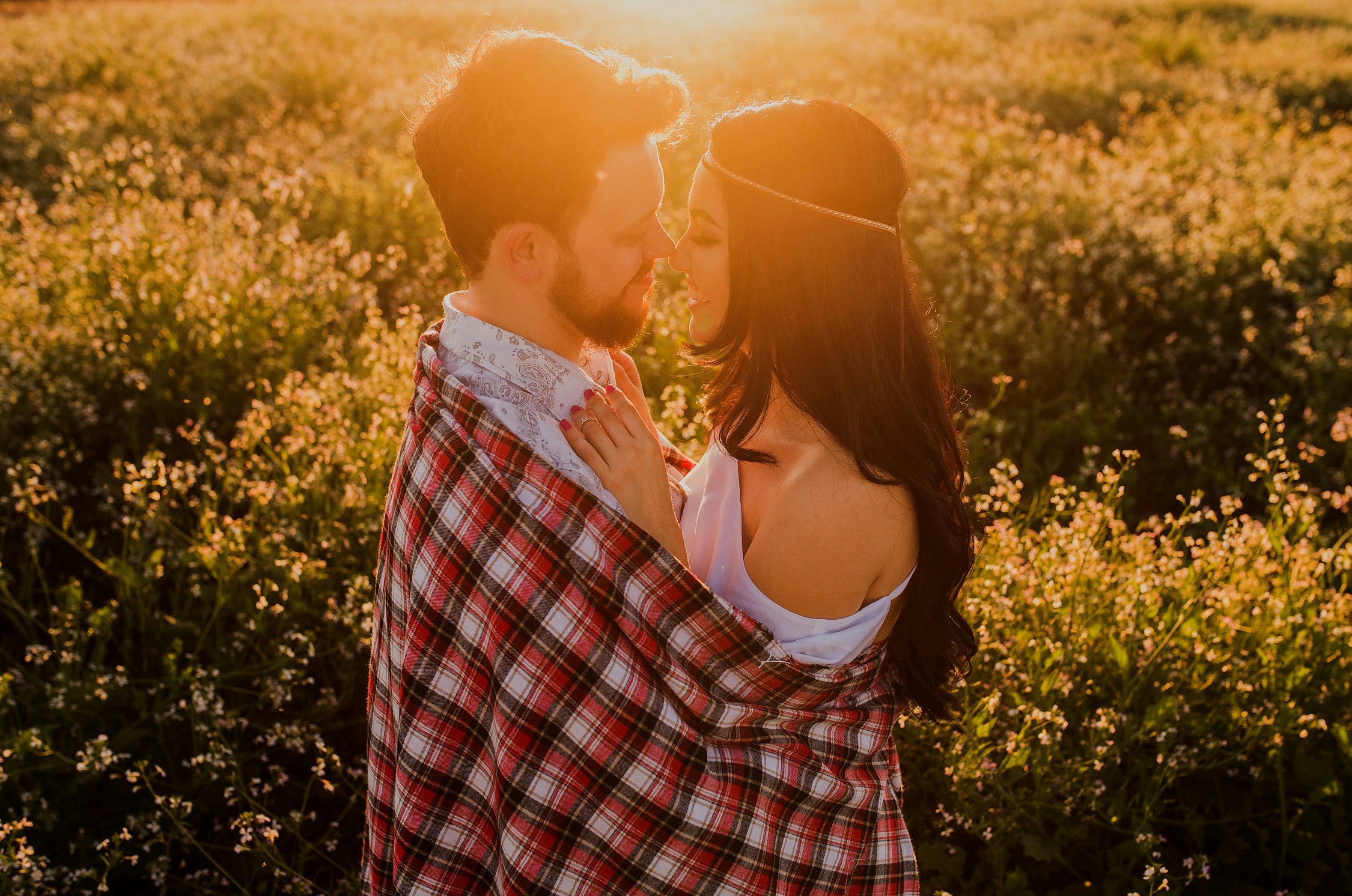 White couple united by matchmakers cuddling in a field