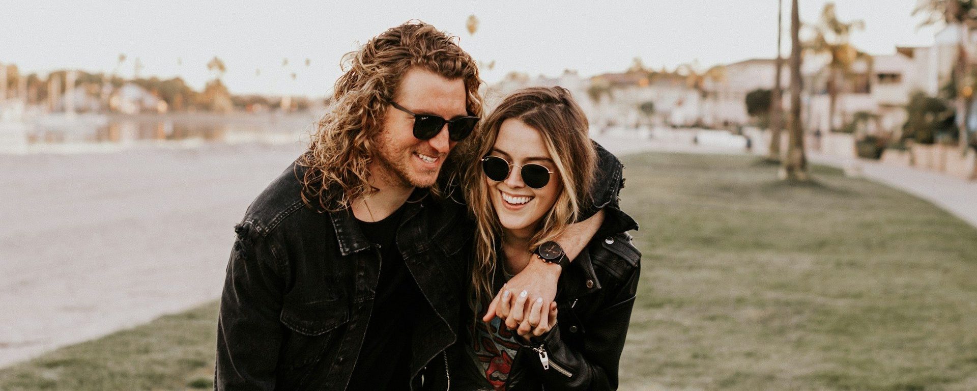 Celibate dating white couple embracing and walking out in public in the grass