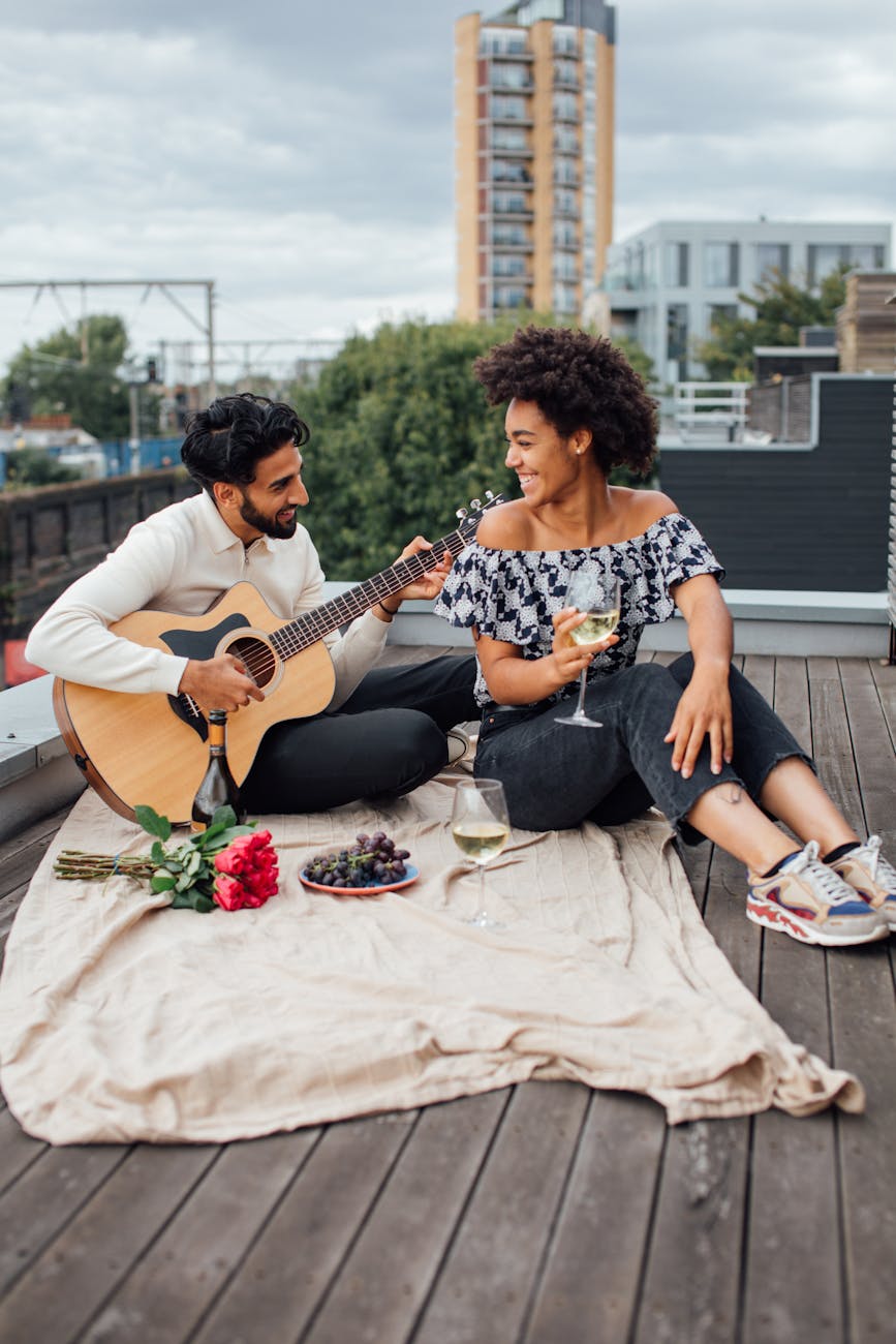 Interracial couple sitting on a roof smiling after being paired at a virtual speed dating event