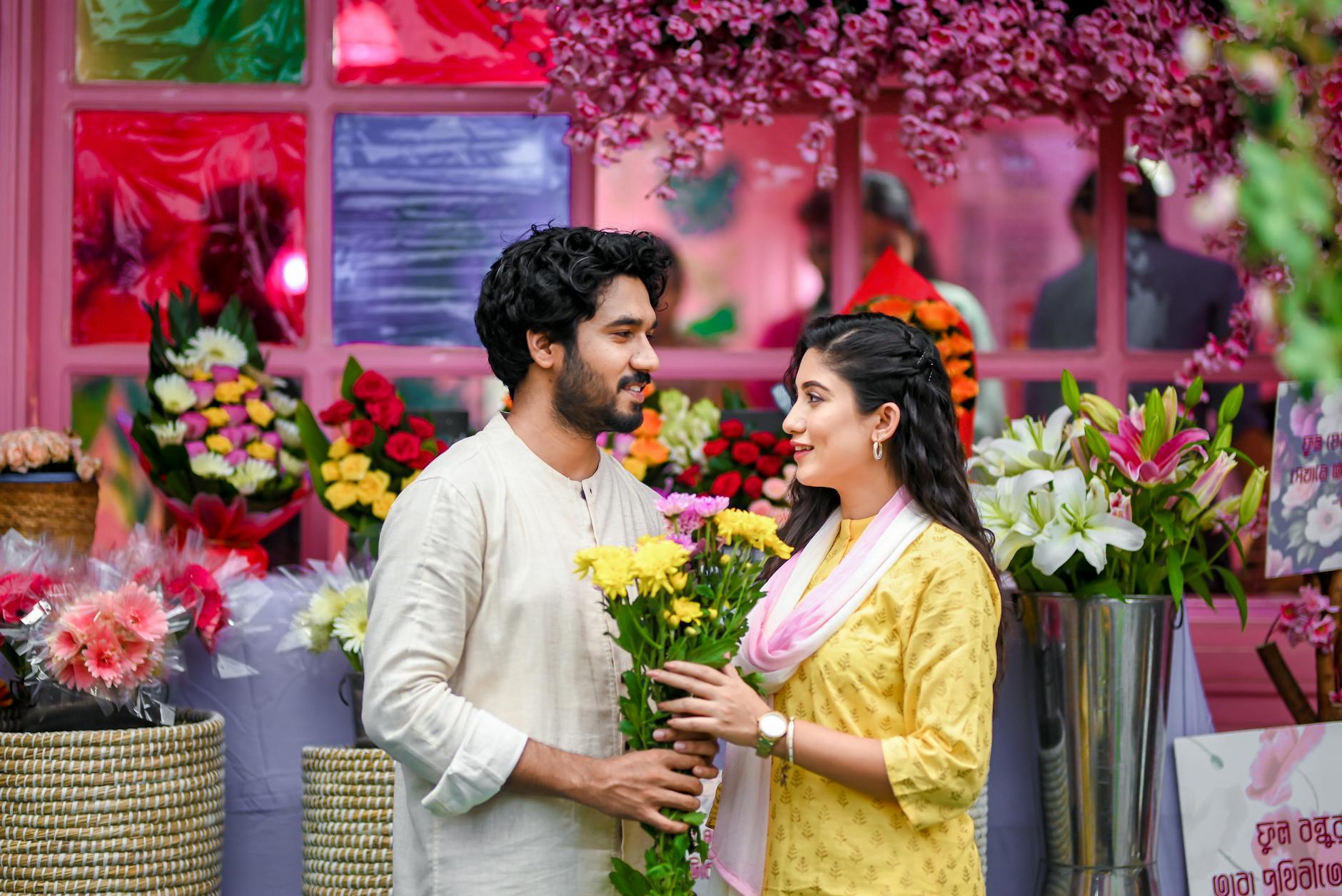 Asian couple introduced by dating coaches cuddling at a flower shop