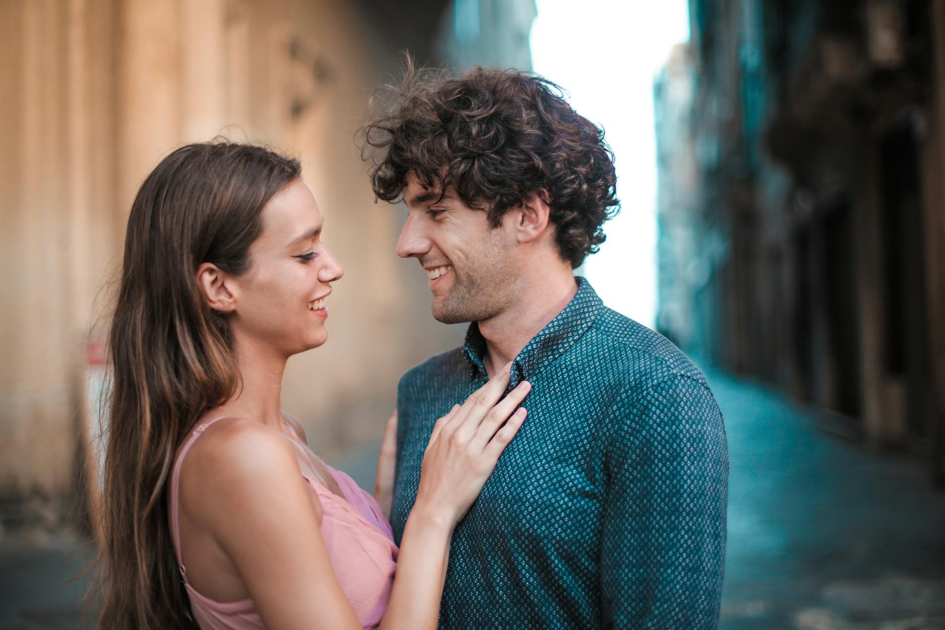 Caucasian couple paired by dating coaches for women standing outside smiling at each other