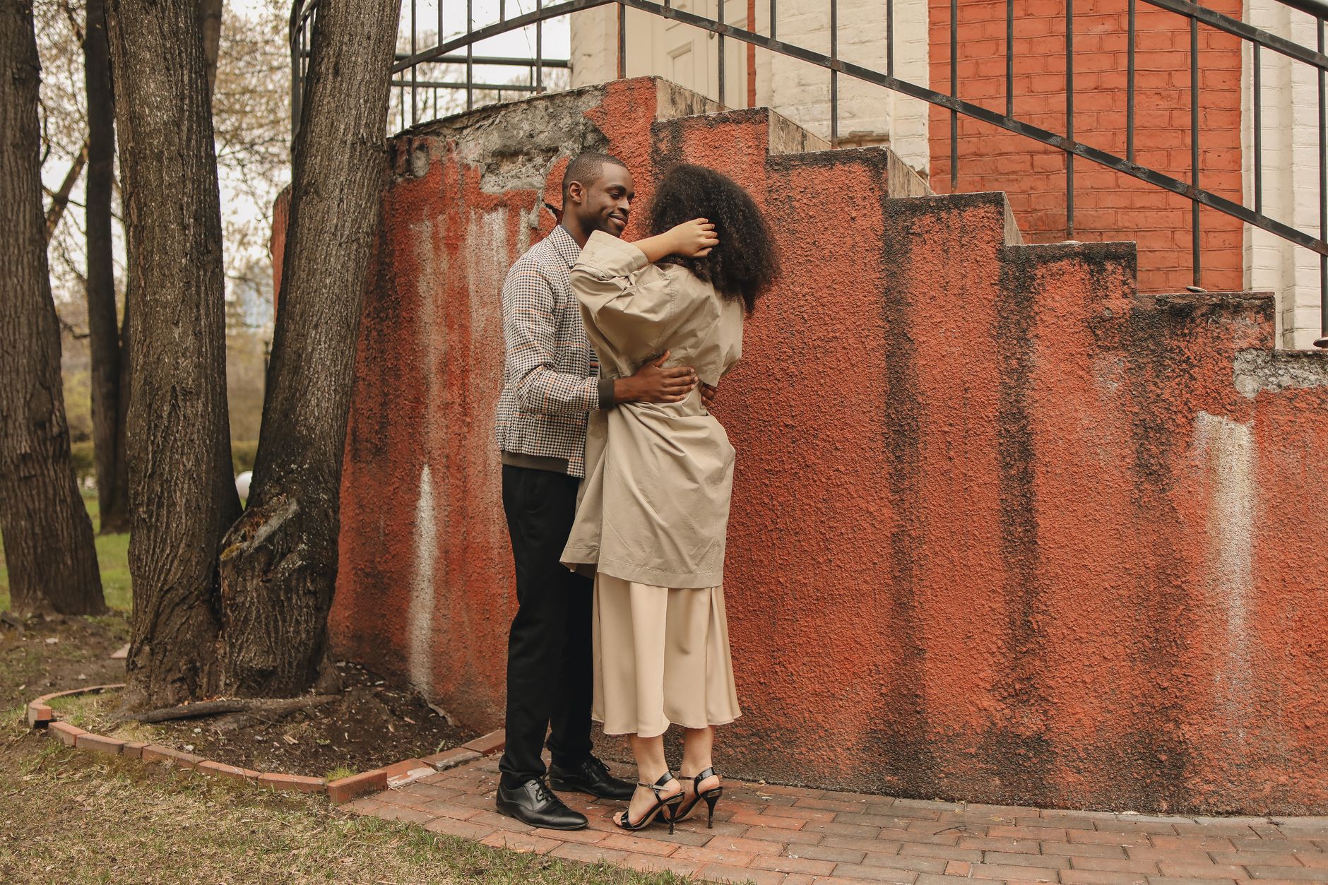 African American couple paired by dating coaches for men standing outside embracing