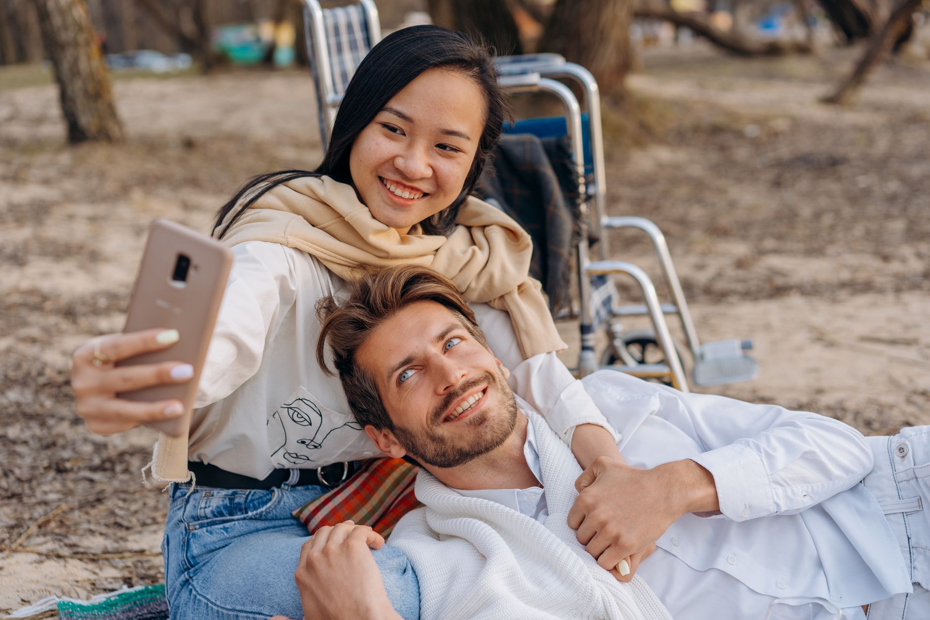 Cute couple embracing on a beach with a wheelchair in the background